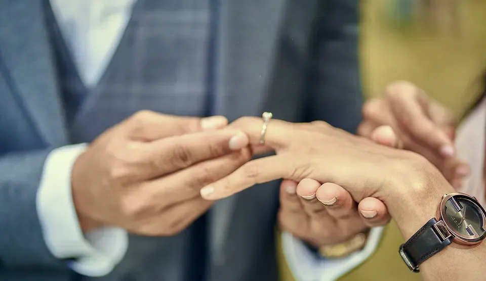 Ramith slipping the ring onto Anu's finger