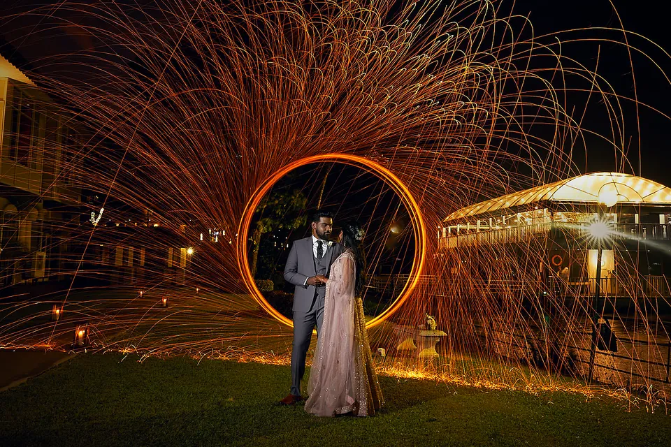 Dishon and Suweda inside a ring of fire-spin sparks at night